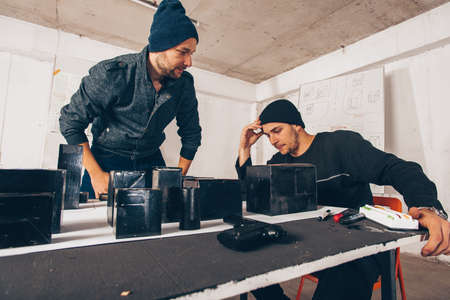 Two young people are sitting in a room, they are talking and planing a robberyの写真素材