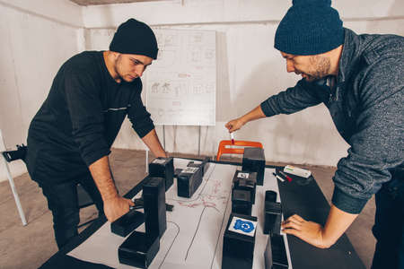 Men are sitting on the desk with a lot of maps and planing a heistの写真素材