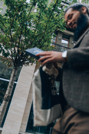 Fashionable male wearing stylish modern clothing during a walk at the city squareの写真素材