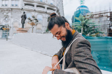 A handsome young hipster guy dressed in modern clothes walking through an urban environmentの写真素材