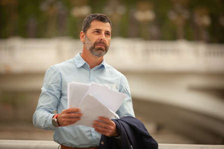 Urban businessman is thinking about the documents in his hands