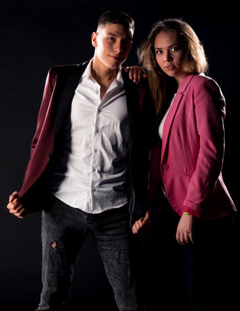 Body shot of attractive male and female models posing in modern clothes