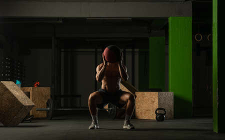 Fit man throwing medicine ball doing ball slam against gym floor or shoulder press exercise.の写真素材
