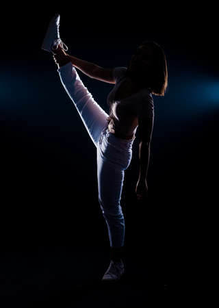Woman balance on one leg, Yoga gymnastics exercise, beautiful sport athletic body on black backgroundの写真素材
