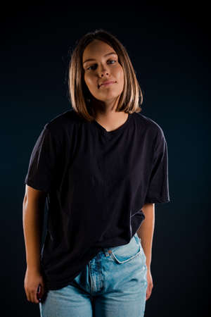 Portrait of an attractive young woman dressed in black top isolated on black backgorundの写真素材