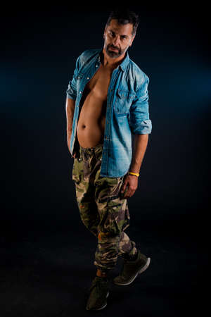 Stylish fashion guy posing topless against dark backgroundの写真素材