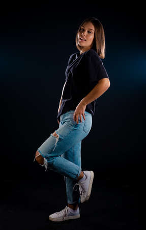 Stylish young woman wearing blue denim pants and sporty tank topの写真素材