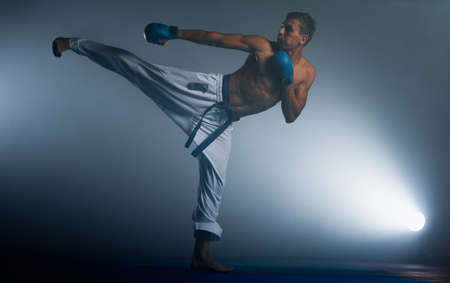 Young man practicing his karate moves, white kimono and red beltの写真素材