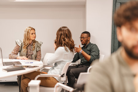 Multiracial, inter-generational coworkers learning together at modern classroom, discussing work, sharing knowledge and ideas.の写真素材