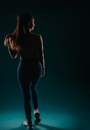 Fit Girl Posing with Confidence in Dark Background: Fitness Model Inspiring Transformation and Resultsの写真素材