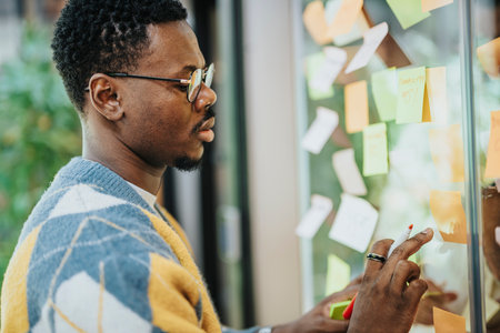 Diverse professionals collaborate in a modern office, discussing business ideas and goals on a glass...