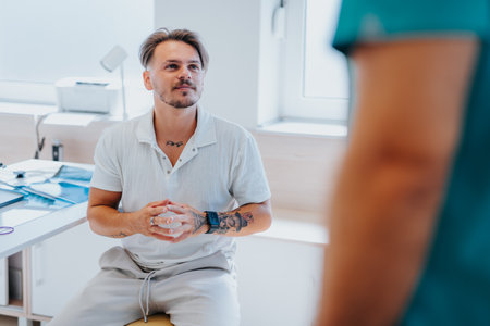 An experienced doctor analyzes x-ray film, advising a young patient in a clinic.の写真素材