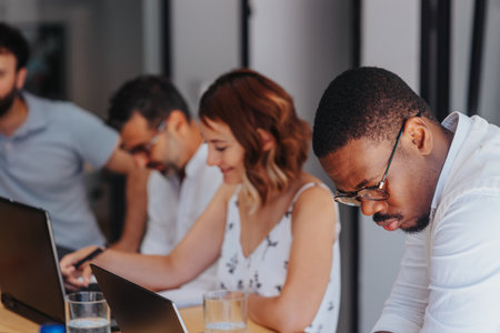 In a diverse office, business partners discuss agenda, solve problems, and make productive decisions for the companys growth.の写真素材