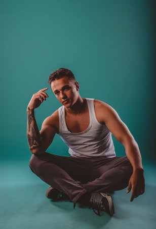 A fit, confident athlete, flexing muscles, showcasing transformation. Turquoise background. Motivational, inspiring progress.の写真素材
