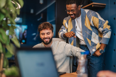 Multiracial professionals in a modern downtown office analyze market research, networking for success in sunny co-working space. Positive atmosphere.の写真素材