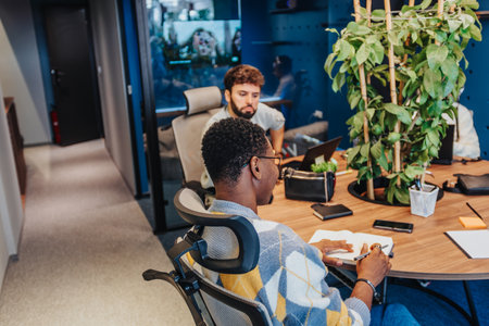 Diverse professionals collaborating in a co-working space, searching for solutions, and achieving...