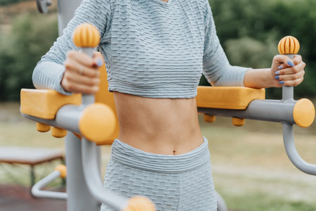 Active and fit girls doing cardio exercises, stretching and training outdoors in a city park....