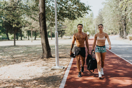 Athletes with fit bodies enjoy a sunny day in the park, discussing the positive results of their outdoor training.の写真素材