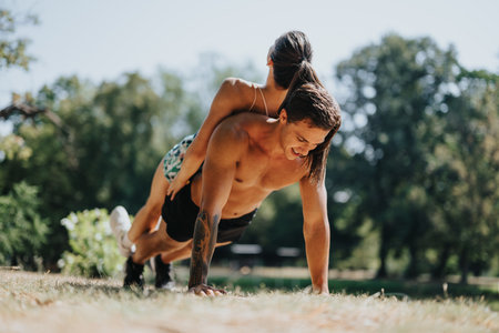 A couple trains outdoors in the park, doing push-ups as part of their daily routine.