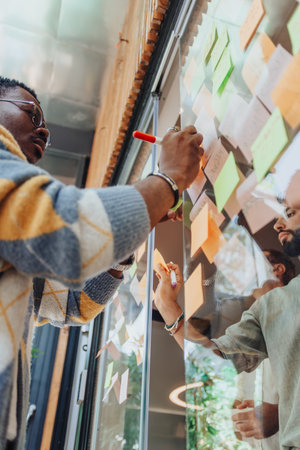 Multigenerational Team Brainstorming Creative Ideas in Modern Glass Officeの写真素材