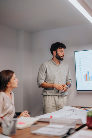 Multiracial Business Team Collaborating in Conference Room with Architectural Blueprintsの写真素材