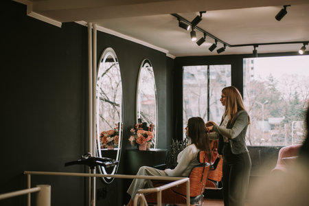 Hairdresser brushing hair and talkingの写真素材