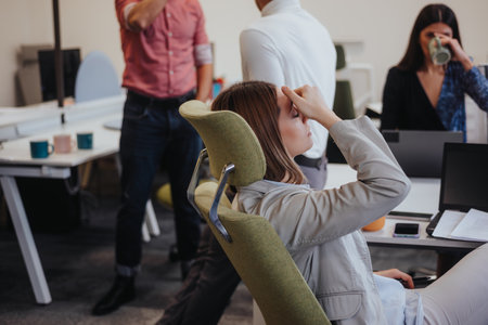 A young, blonde woman is experiencing headaches due to a migraine during her work shift in the...