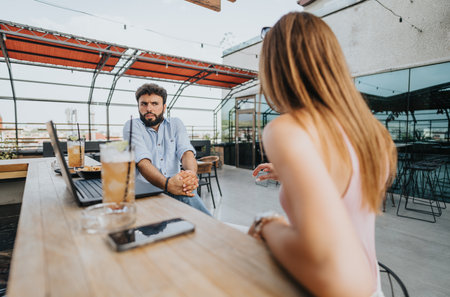 Successful Young Business Couple Talks Growth Strategy over Coffee in Urban Cafe
