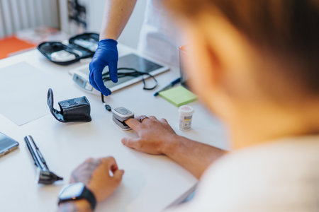 Experienced doctor checking patients health with care. Using glucometer, otoscope, and performing...