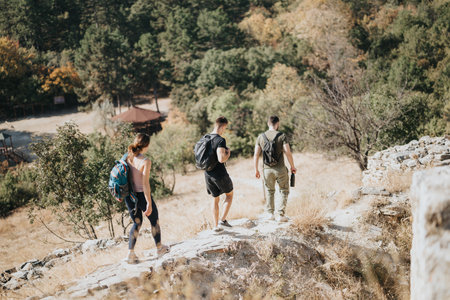 Enjoying a Sunny Day in the Wilderness. Friends Hiking on a Trail in the Green Forestの写真素材