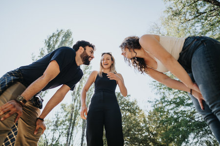 A joyful group of friends in a city park, enjoying a sunny day off. Theyre carefree, having fun, and socializing in the green environment.の写真素材