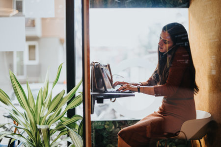 A businesswoman in a soundproof phone booth negotiating a deal during an online meeting.の写真素材