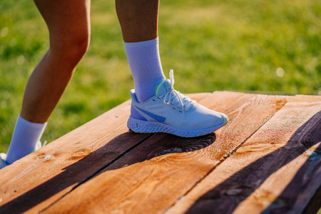 A photo of sporty girls legs in sports sneakers and socks