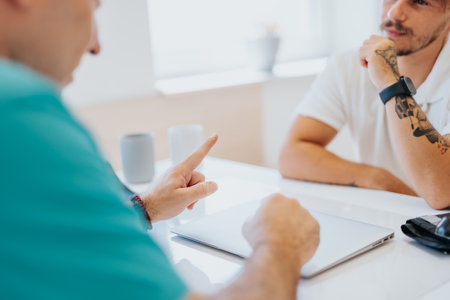 Two people in a clinic discuss medical test results with a doctor and nurse.の写真素材