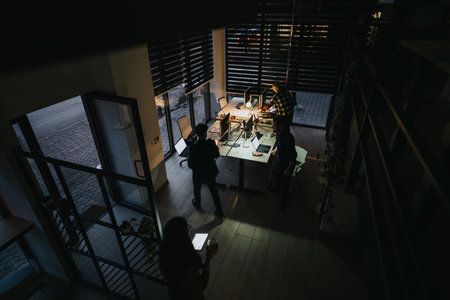 Late night teamwork of business people, discussing project details and collaborating on tasks planning for business growth and success.の写真素材