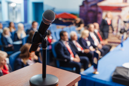 Microphone on podium. Blurred background of business people waiting for seminar, conference or...
