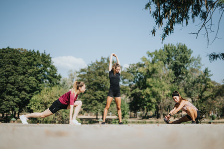 Fit and active women having fun in the park, stretching and warming up before their outdoor workout.の写真素材