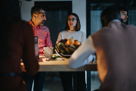 A dedicated team working late to meet a deadline, analyzing statistics and sharing innovative business strategies for growth and success.の写真素材