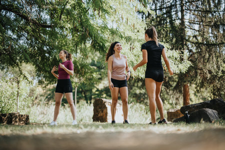 Active females stretching outdoors, staying fit and flexible, enjoying a sunny day in the park.の写真素材