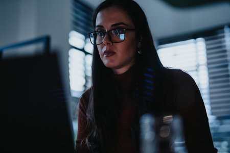 Young businesswoman working on lap top on a late evening at the office.の写真素材