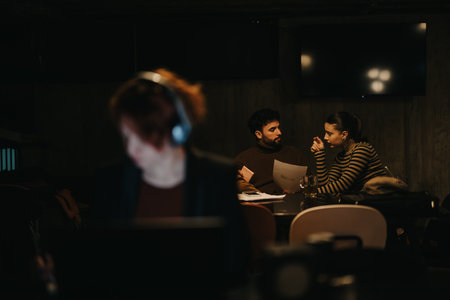 Young business people working together at the office. Female employee working separately from her teammates.の写真素材