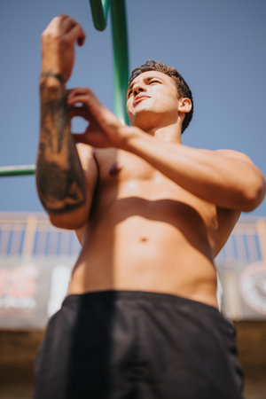 A couple of professional athletes engaging in outdoor exercise, challenging themselves on horizontal bars.の写真素材