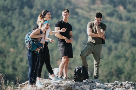 Young friends hike through the forest, enjoying a sunny day exploring nature and engaging in physical activity.の写真素材