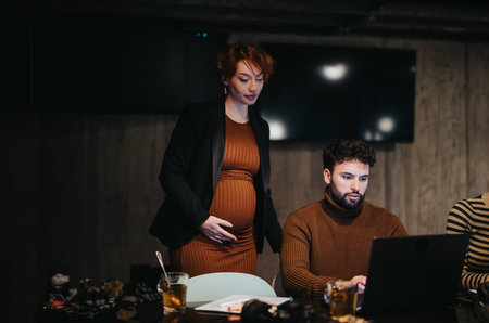 A team of young business people working late in a corporate office, analyzing data and coordinating tasks planning for business growth and revenue.の写真素材
