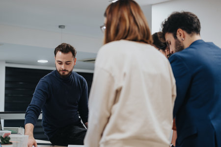 Diverse business team brainstorming late at night to meet project deadline, analyzing reports and strategizing sales growth for target group.の写真素材