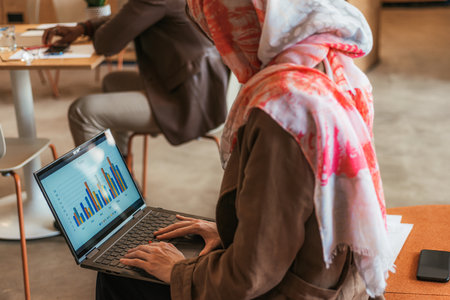 Business creative woman reading sales stats, graph charts using lap top computer at workの写真素材