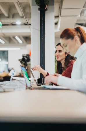 Diverse business professionals collaborating in a pleasant office atmosphere, discussing financial...