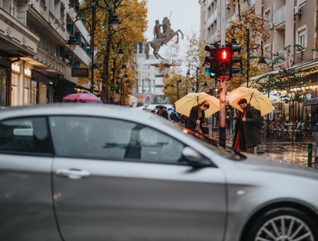 Business people working on a rainy day. They are waiting for a green traffic light.の写真素材
