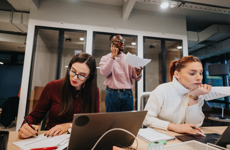 Creative business team collaborating on budgeting and accounting reports in a pleasant office atmosphereの写真素材