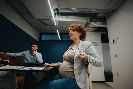 Multiracial coworkers collaborating in a creative office, discussing market expansion strategies and analyzing statistics for profit growth.の写真素材